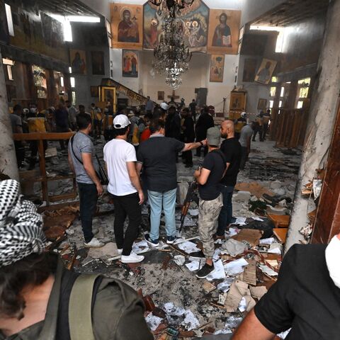 People and rescuers inspect the damage at the site of a reported suicide attack at the Saint Elias church in Damascus on June 22, 2025. 