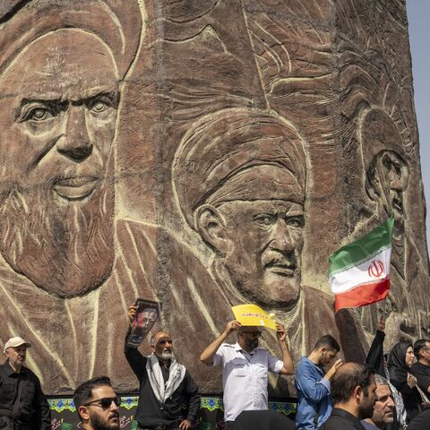 People stand near a monument to Iran's late former leader, Ayatollah Khomeini, as thousands of Iranians attend the funeral ceremony for approximately 60 people killed in Israeli strikes on Iran, on June 28, 2025, in Tehran, Iran.