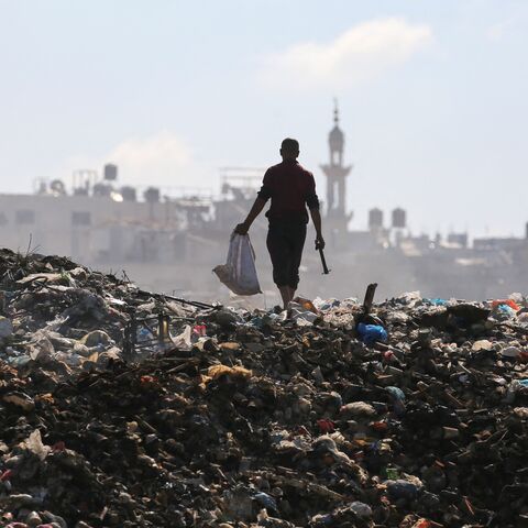 A Palestinian man searches for things to rescue at a garbage waste dump in the Al-Bureij camp in the central Gaza Strip on July 7, 2025.