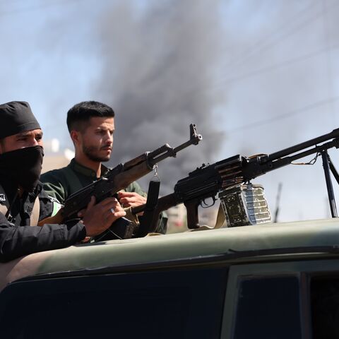 Syrian security forces stand with their guns atop a truck on July 15, 2025, near Suwayda, Syria.