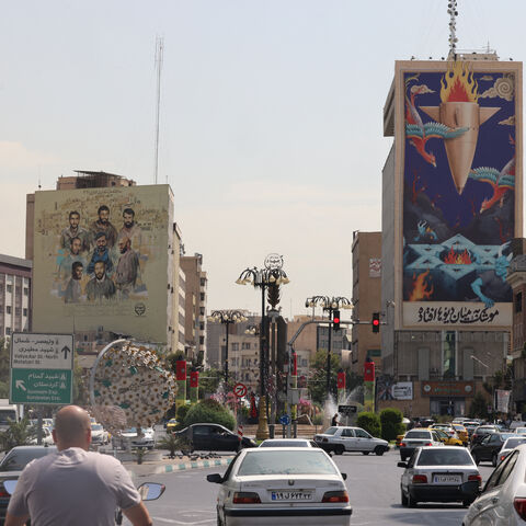 Traffic flows past a huge billboard bearing a painting of a missile falling on Israel with the slogan in Farsi: "The missile has fallen amidst the demons", on a main road in central Tehran on July 16, 2025. A 12-day war between Iran and Israel last month was sparked by an Israeli bombing campaign that hit military and nuclear sites as well as residential areas in Iran. (Photo by ATTA KENARE / AFP) (Photo by ATTA KENARE/AFP via Getty Images)