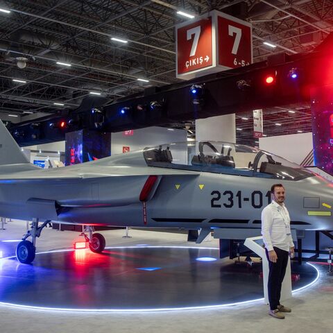 People pose for photographs in front of a Turkish Hurjet at the 17th International Defense Industry Fair (IDEF), Istanbul, July 24, 2025.