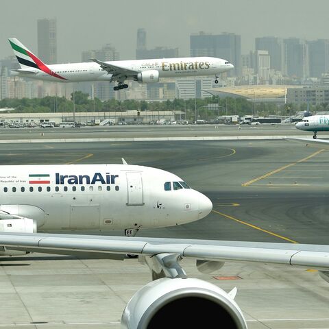 An Emirates Boing 777 lands while an Iran Air plane is taxiing, Dubai's International Airport, Sept. 14, 2017.