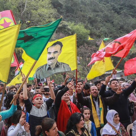 Members of the Lebanese Kurdish community wave the flags of (L to R) the Kurdish People's Protection Units (YPG), Women's Protection Units (YPJ), another showing jailed Kurdish militant leader Abdullah Ocalan, and the flag of the Kurdistan Workers' Party (PKK), during a celebration marking the spring festival of Nowruz (Noruz) in Lebanon's coastal town of Damour, 24 kilometers south of Beirut, on March 24, 2019.