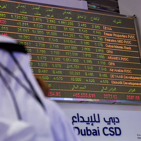 A man watches stock movements on a display at the Dubai Financial Market stock exchange, United Arab Emirates, April 12, 2022.
