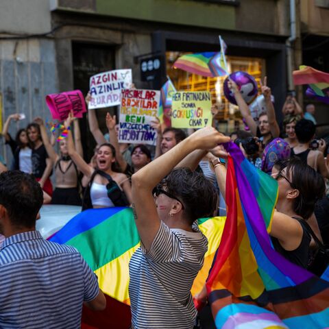 Protesters hold up placards and rainbow flags as they take part in the LGBTQ Pride March in Istanbul, June 25, 2023.