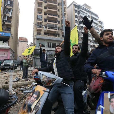 Hezbollah supporters wave the yellow flag of the Lebanese militant group during a parade on motorbikes while people returned to the area to check their homes in Beirut's southern suburbs on Nov. 27, 2024, after a ceasefire between Israel and Hezbollah took effect. 