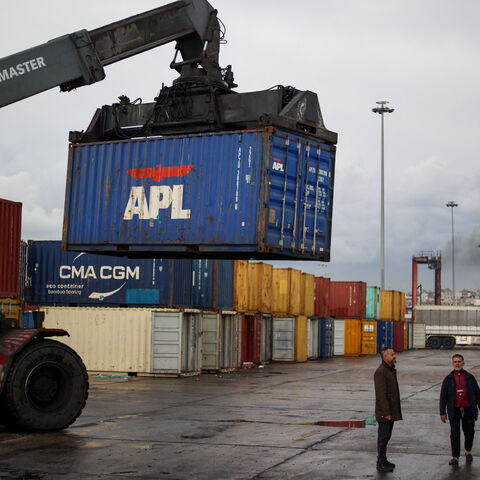 People unload containers at the port of Latakia in western Syria on Dec. 30, 2024. 