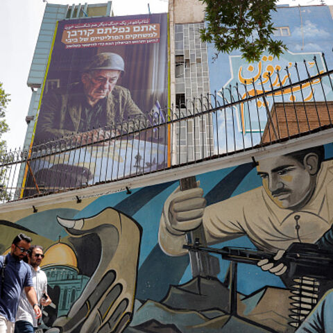 Pedestrians walk past a mural at Palestine Square in central Tehran on July 8, 2025, as an anti-Israeli billboard is displayed on the facade of a building depicting the Israeli prime minister Benjamin Netanyahu with text in Persian and Hebrew reading "Netanyahu lost another war; you fell victim to Bibi's political games; Where will the next failure to stay in power occur?" (Photo by -- / AFP) (Photo by --/AFP via Getty Images)