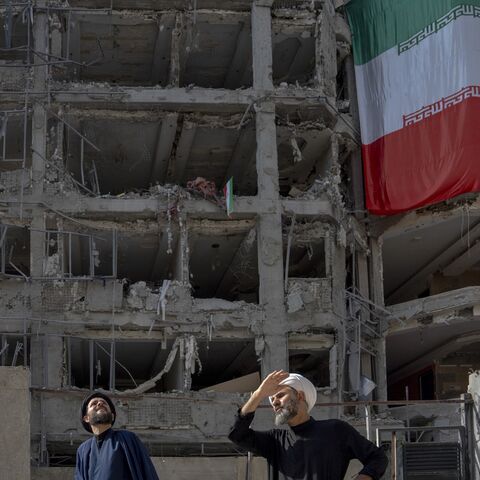 Two men look at houses destroyed in Israeli attacks, July 12, 2025, Tehran.