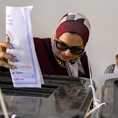 TOPSHOT - A voter casts her ballot at a polling station in a school in the district of Agouza in the Egyptian capital's twin city of Giza on the first day of the 2025 Egyptian Senate elections on August 4, 2025. Egypt's two-day vote beginning on August 4 will elect 200 of the 300 seats in the upper chamber of parliament, with the remaining third appointed directly by President Abdel Fattah al-Sisi, the former army chief who came to power after ousting Islamist president Mohamed Morsi in 2013. (Photo by Khal