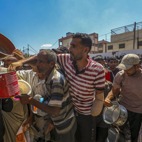 Peoples waits near a humanitarian aid distribution point at the Nuseirat refugee camp in central Gaza on July 20, 2025, amid a deepening food crisis. 
