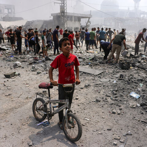 A young boy stands next to his bicycle as Palestinians check the devastation following an Israeli strike that hit Gaza City's southern al-Zeitoun neighbourhood on August 8, 2025. Israel's military will "take control" of Gaza City under a new plan approved by Prime Minister Benjamin Netanyahu's security cabinet, touching off a wave of criticism Friday from both inside and outside the country. (Photo by BASHAR TALEB / AFP) (Photo by BASHAR TALEB/AFP via Getty Images)