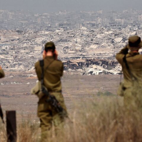 Israeli army soldiers look at the destruction in Gaza from the border with the Palestinian territory, Aug. 13, 2025.