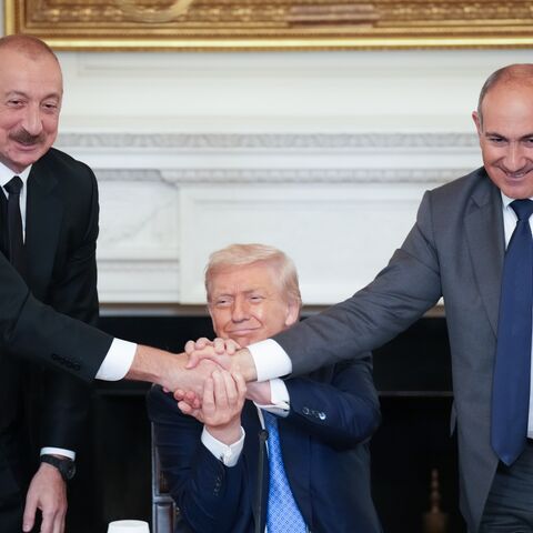  US President Donald Trump (C) joins hands with Azerbaijani President Ilham Aliyev (L) and Armenian Prime Minister Nikol Pashinyan (R) during a signing ceremony in the State Dining Room of the White House, Washington, DC, Aug. 8, 20
