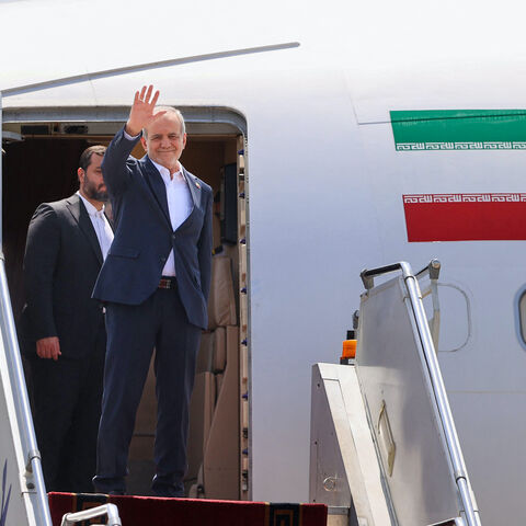 Iran's President Masoud Pezeshkian waves as he boards a plane at Tehran's Mehrabad Airport on Aug. 18, 2025, ahead of his trip to Armenia. 