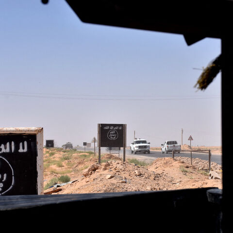 Billboards show the logo of the Islamic State (IS) group near the village of al-Maleha, in the northern countryside of Deir Ezzor, where Syrian pro-government forces are holding a position on September 9, 2017, during the ongoing battle against IS jihadists. Syrian troops broke the Islamic State group's siege of the eastern Deir Ezzor military airport, dealing a new blow to the jihadists who were facing a new offensive from US-backed fighters elsewhere in the province. (Photo by George OURFALIAN / AFP) (Pho