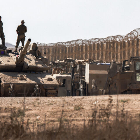 Israeli army soldiers stand atop the turret of a Merkava main battle tank positioned near armoured military bulldozers along the border with the Gaza Strip in southern Israel on Sept. 2, 2025.