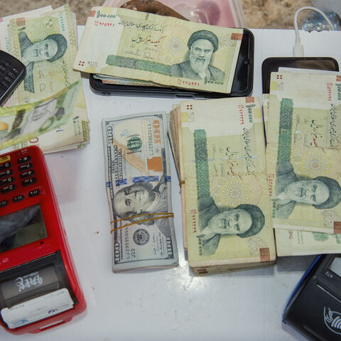 Stacks of Iranian rials and US dollars sit counted on a table in an unofficial currency exchange shop, Tehran, Iran, Aug. 6, 2025.