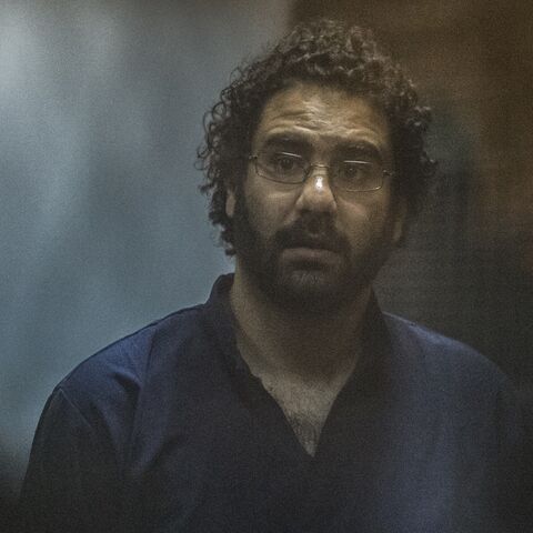 Egyptian activist and blogger Alaa Abdel Fattah looks on from behind the defendant's cage during his trial for insulting the judiciary alongside 25 other defendants including ousted Egyptian president Mohamed Morsi, who was recently sentenced to death, in Cairo on May 23, 2015.