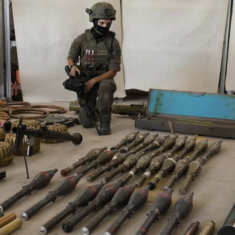 An Israeli soldier displays military equipment and ammunition that Hamas and Palestinan militants used at the time of the attack on the Israeli south border with the Gaza Strip on Oct. 20, 2023, in Kiryat Malakhi, Israel.