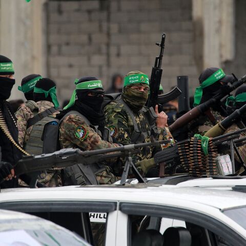 Palestinian Hamas fighters carry their guns in Nuseirat in the central Gaza Strip as preparations take place for the release of three Israeli hostages, as part of the seventh hostage-prisoner swap on Feb. 22, 2025.