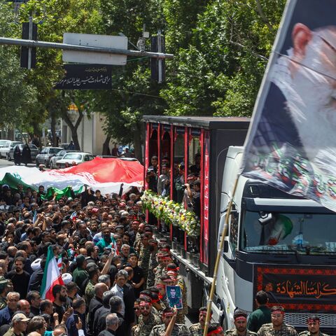 In this picture obtained from Iran's ISNA news agency, a flag with the portrait of Iran's supreme leader, Ayatollah Ali Khamenei, is waved during the funeral procession of 15 people killed in Israeli strikes during the 12-day war between Israel and Iran, in the city of Mashhad on June 27, 2025. 