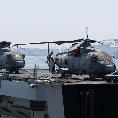 TOKYO, JAPAN - AUGUST 31: Members of the British Royal Navy walk near helicopters parked aboard HMS Prince of Wales, the navy's flagship aircraft carrier, during a public ship tour at the Tokyo International Cruise Terminal on August 31, 2025, in Tokyo, Japan. The aircraft carrier was opened to the public in connection with the UK Carrier Strike Group's (CSG) port call in Tokyo. The group has been in Japan since August 12 for joint training exercises. (Photo by Tomohiro Ohsumi/Getty Images)