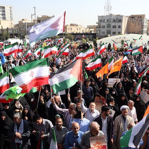 Protesters wave Iranian and Palestinian flags in solidarity with the Palestinian people in Gaza during a demonstration in Tehran on Oct. 10, 2025.