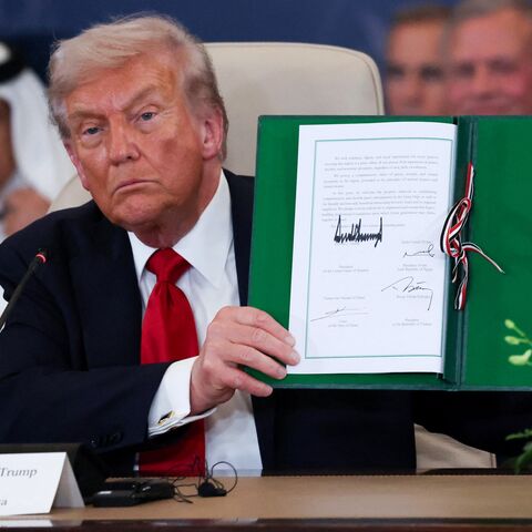 President Donald Trump poses with the signed agreement at a world leaders' summit on ending the Gaza war on Oct. 13, 2025, in Sharm el-Sheikh, Egypt. 