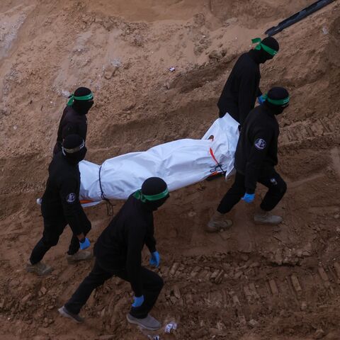 Hamas militants carry a body retrieved from a tunnel in an area north of Khan Yunis in the southern Gaza Strip, on Oct. 28, 2025. 