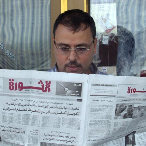 A Syrian reads the state-run daily newspaper al-Thawra outside his shop in downtown Damascus on Sept. 3, 2004.