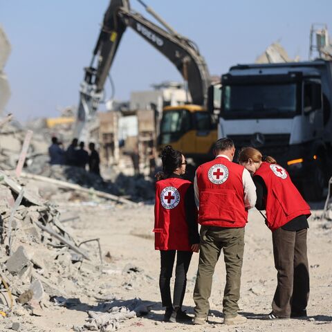 Members of the Red Cross stand amid the rubble of destroyed buildings as heavy machinery operates in the al-Tuffah neighborhood of Gaza City on Oct. 27, 2025. 