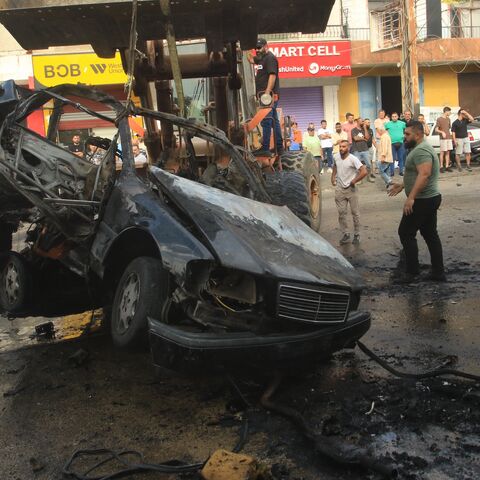 A bulldozer removes the wreckage of a vehicle targeted by an Israeli drone strike in the southern Lebanese village of Doueir near the city of Nabatieh, on Nov. 3, 2025. 