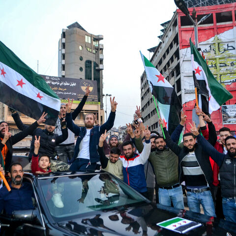 TOPSHOT - Syrian and Lebanese people in the northern Lebanese city of Tripoli celebrate on December 9, 2024, after Islamist-led rebels declared that they have taken the Syrian capital in a lightning offensive, sending President Bashar al-Assad fleeing and ending five decades of Baath rule in Syria. (Photo by Fathi AL-MASRI / AFP) (Photo by FATHI AL-MASRI/AFP via Getty Images)