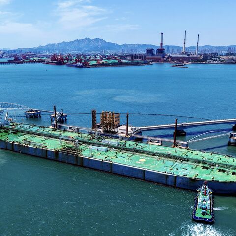 A ship loaded with oil docks at a pier with the help of a tugboat at the port of Qingdao, in eastern China's Shandong province, on June 12, 2025.