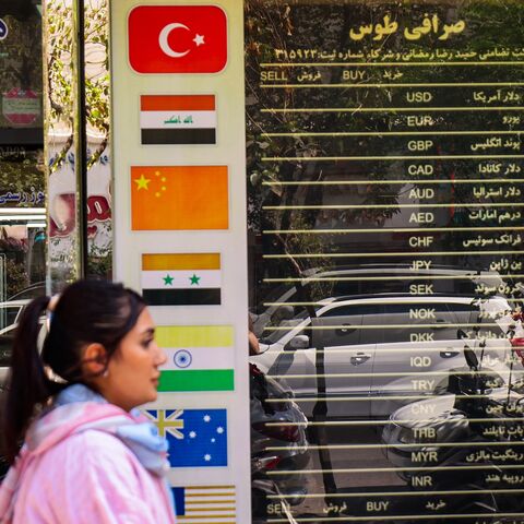 A woman walks past a currency exchange office in Tehran on Sept. 28, 2025, as Iranians feel economic strain deepen, with prices soaring and the rial sinking to new lows. 