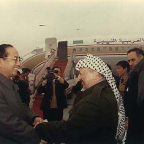 A file photo shows Zhao Qizheng[L], then deputy mayor of Shanghai and current minister of the State Council Information Office, hand in hand with Yasser Arafat in this file photo taken in 1991 at Shanghai's Hongqiao Airport. [China Daily]