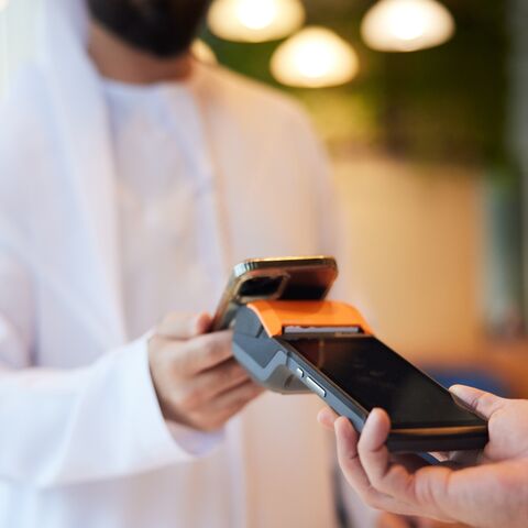 The close-up of a phone tapping a POS at the coffee shop highlights the ease of contactless transactions.