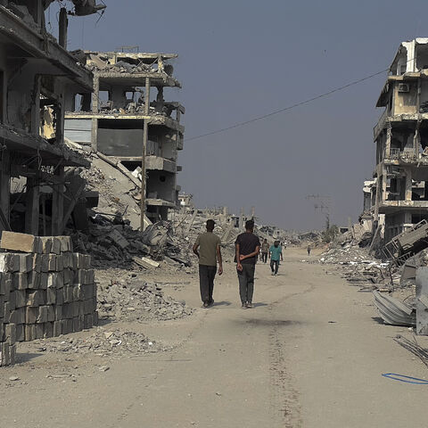 Men pass by the destroyed Haifa Bakery in Khan Yunis, Gaza Strip, on Nov. 6, 2025. 