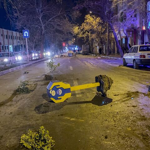 Rocks, tree branches, and a toppled charity box remain on a street during unrest amid demonstrations in Hamedan, Iran, on Jan. 1, 2026