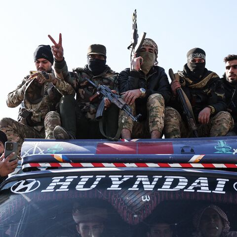 Syrian government forces ride on the roof of a vehicle as they deploy after crossing the Euphrates River in the province of Deir Ezzor, eastern Syria, on Jan. 19, 2026.