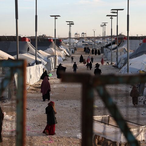 Children and women, relatives of suspected Islamic State jihadists, walk inside al-Hol camp in the desert region of Syria's northeastern Hasakah province, on Jan. 21, 2026.