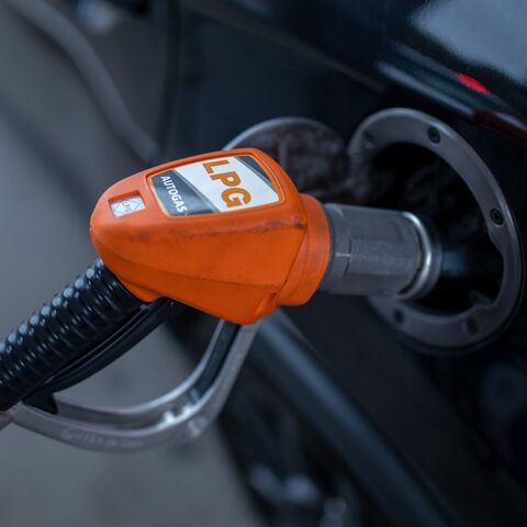 Close-up of an LPG dispenser nozzle filling a car's fuel tank. This illustrates the use of alternative fuel sources for automobiles. LPG is a cleaner-burning fuel compared to gasoline.
