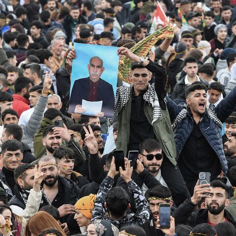 A man holds a poster of Abdullah Ocalan, Turkish-jailed founder of the Kurdistan Workers Party (PKK), during a gathering of Turkish Kurds for Nowruz celebrations in Diyarbakir, southeast Turkey, on March 21, 2025. 