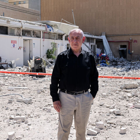 Israeli Prime Minister Benjamin Netanyahu stands amid debris outside the Soroka Hospital in the southern city of Beersheba, after it was hit by a missile fired from Iran on June 19, 2025. Israel's defence minister warned that Iran's supreme leader "can no longer be allowed to exist" after a hospital was hit in an Iranian missile strike on June 19, spiking tensions in the week-old war. (Photo by Marc Israel SELLEM / POOL / AFP) (Photo by MARC ISRAEL SELLEM/POOL/AFP via Getty Images)
