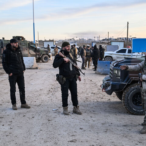 Members of Syrian security forces at the entrance of the al-Hol camp in the desert region of Hasakah province which holds around 24,000 people, including some 6,200 women and children from around 40 nationalities on Jan. 21, 2026 in Al Hasakah, Syria.  
