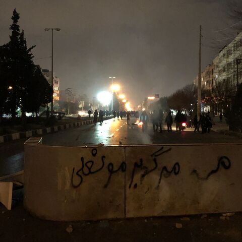 Iranian protesters block a street as a slogan against Iran's supreme leader is spray-painted nearby during a demonstration in Shiraz, Iran, on Jan. 10, 2026. 