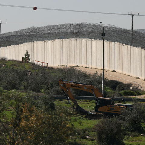 The Israeli built controversial separation barrier is seen passing through fields near the Palestinian village of Beit Aawa, west the Israeli-occupied West Bank city of Hebron on Feb. 5, 2026. 