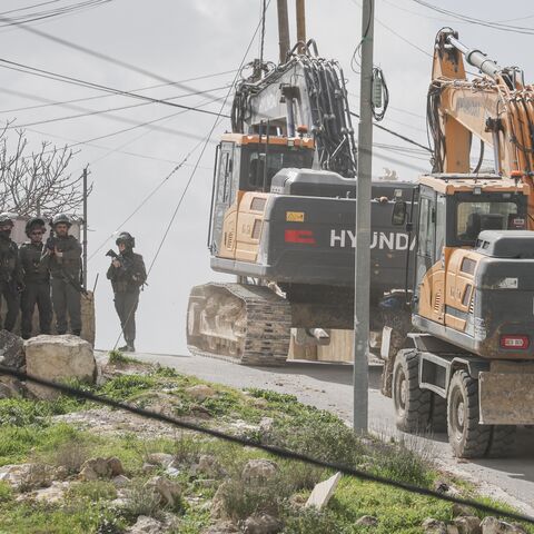 Excavators move along a street as Israeli forces are deployed during the demolition of the home of Palestinian Tariq al-Masalmeh in the village of Beit Awa, southwest of Hebron in the occupied West Bank, on Feb. 11, 2026. 